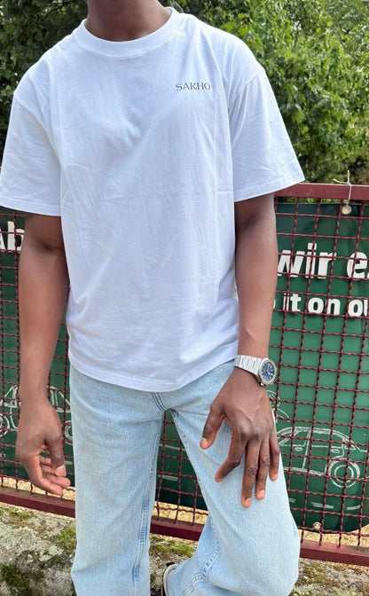 Model wearing the white SAKHO Quiet Strength Tee, front view.